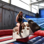 A girl riding a mechanic bull during CAB Fest 2023 – Route 56, on Chièvres Air Base, Belgium, Sept. 16, 2023. (U.S. Army photo by Pascal Demeuldre)