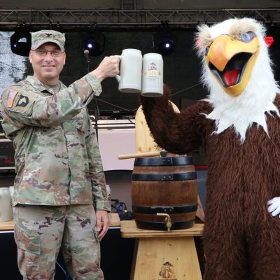 Der Kommandeur der U.S. Army Garrison Wiesbaden, Colonel David Mayfield, und das Adler-Maskottchen von AFN Wiesbaden stoßen auf die offizielle Eröffnung des German American Friendship Fest 2023 an. -- Bild: US-Armee von Michael Kenfield