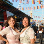 on links posieren die US-Militärangehörigen Jillian Milanes und Bianca Camarena in ihren traditionellen deutschen Festtagsoutfits, den Trachten, für ein Foto. -- Bild: U.S. Army von Bryan Gatchell, USAG Bavaria Public Affairs